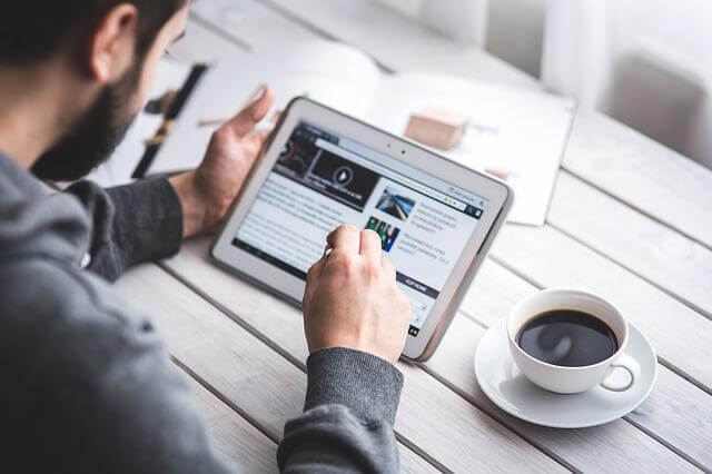 man reading touchscreen blog